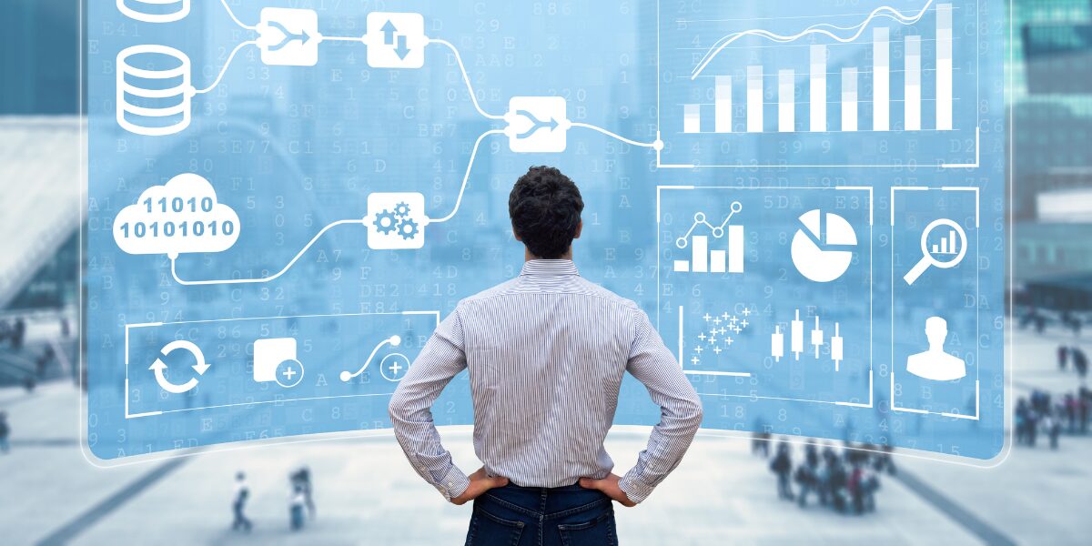 an image of a man standing infront of blue screen with charts and graphs
