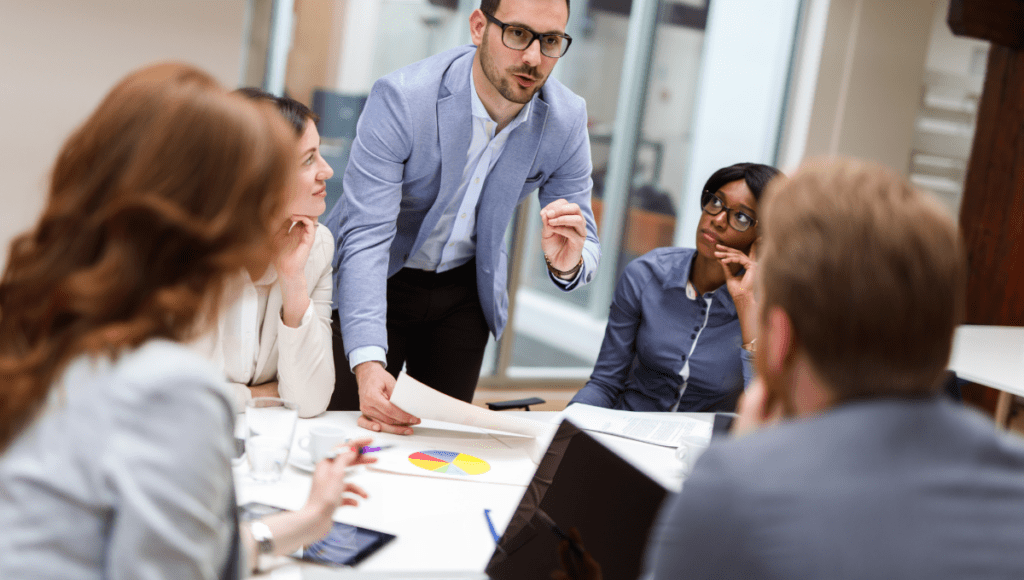 A team of project managers discussing critical chain project management around a table.